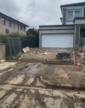 Mud and debris across a driveway and footpath, flagged for attention