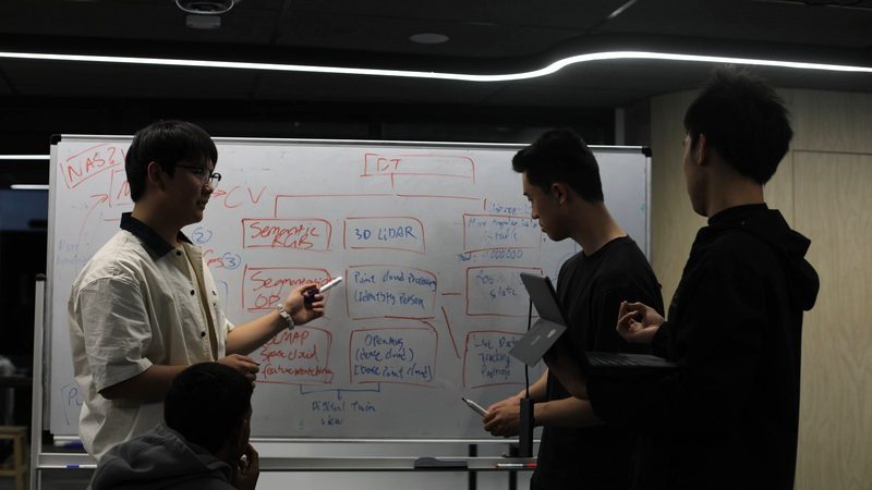VISTA members mapping out a system architecture on the whiteboard