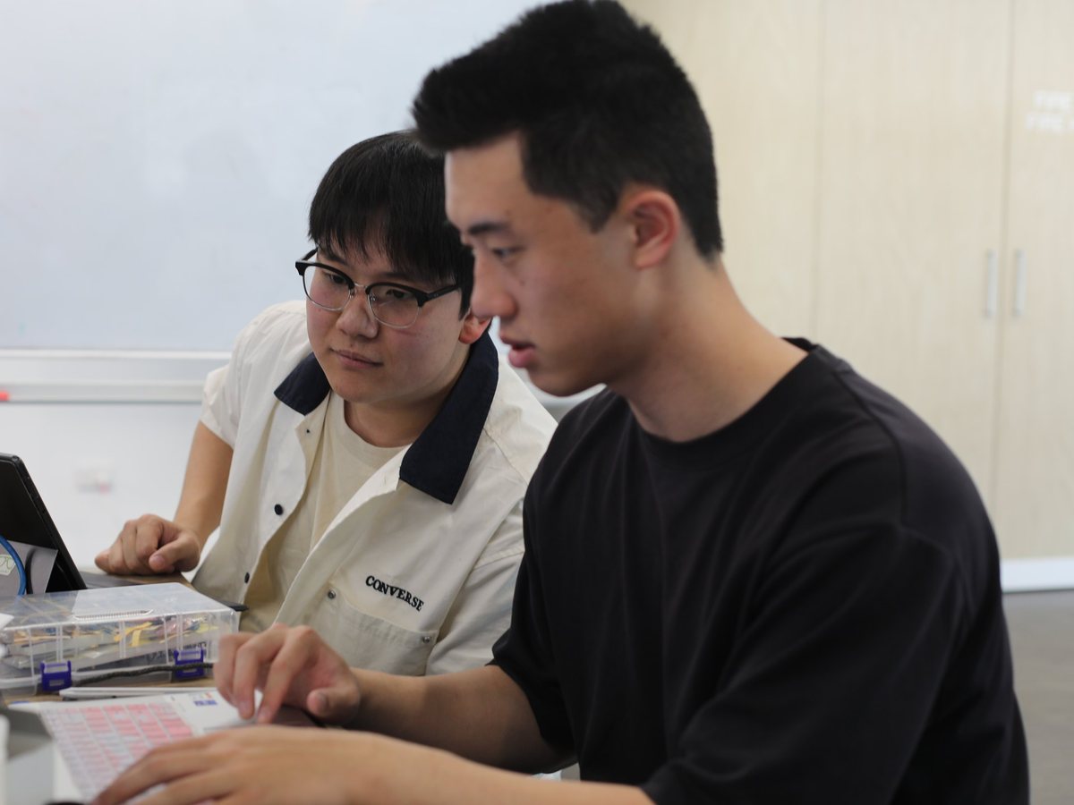 Two VISTA members working on sensor hardware at a laptop