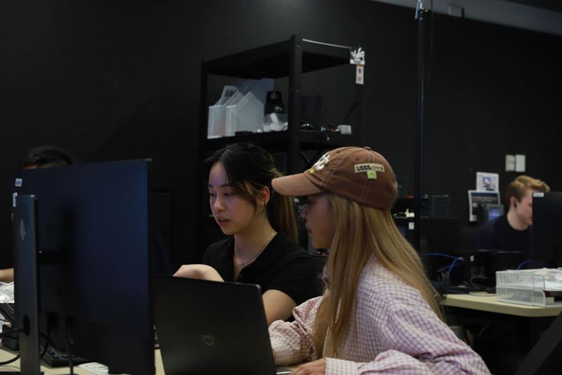 Two members working together at a laptop in the lab